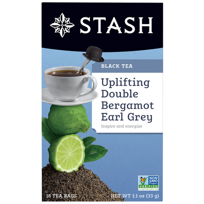 Stash tea package with a cup of tea, lime, and bergamot on a blue background