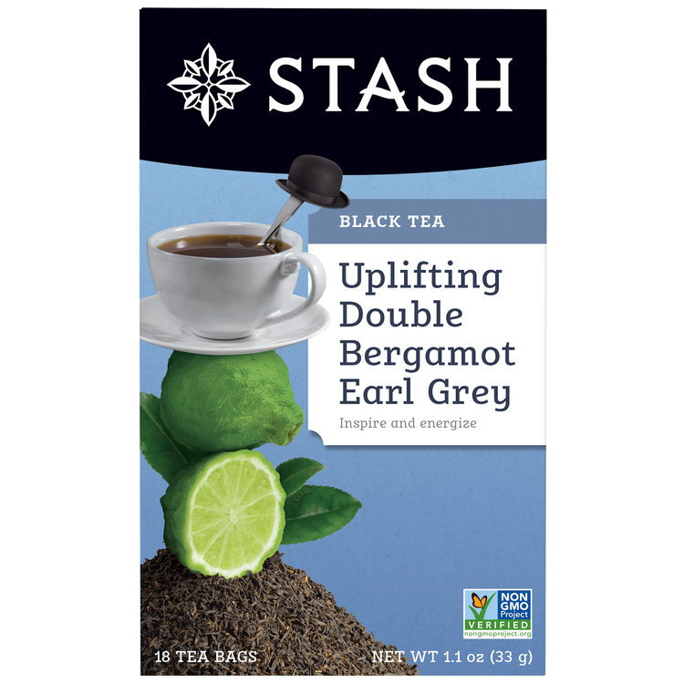 Stash tea package with a cup of tea, lime, and bergamot on a blue background