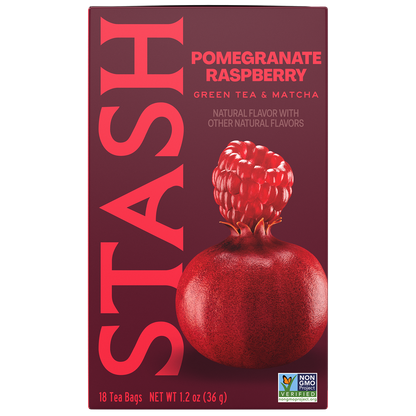 A box of Stash Pomegranate Raspberry green tea and matcha tea bags. The packaging is a deep burgundy color with large pink vertical 'STASH' lettering and a graphic of a red pomegranate with a raspberry on top.